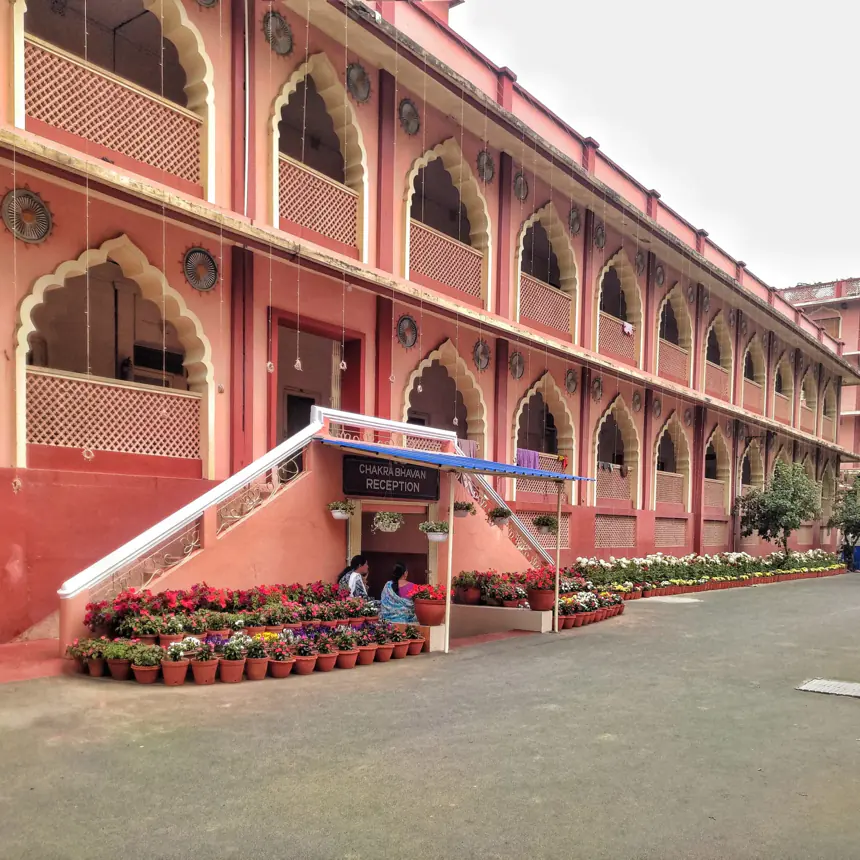An arcaded residential block with flowering plants kept along its frontage